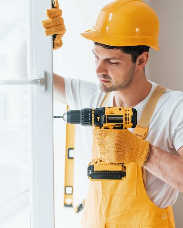 handyman-in-yellow-uniform-installs-new-window-e1663969295597.jpg